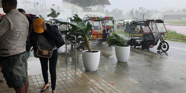 Storm evacuees take cover as strong winds blow in Dapa town, Siargao, Surigao del Norte province, southern Philippines on Thursday, Dec. 16, 2021. 