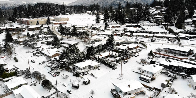 In this photo taken from a drone, snow covers streets, sidewalks and homes where nearly a foot of snow fell over the weekend, Monday, Dec. 27, 2021, in a neighborhood in Bellingham, Washington. 