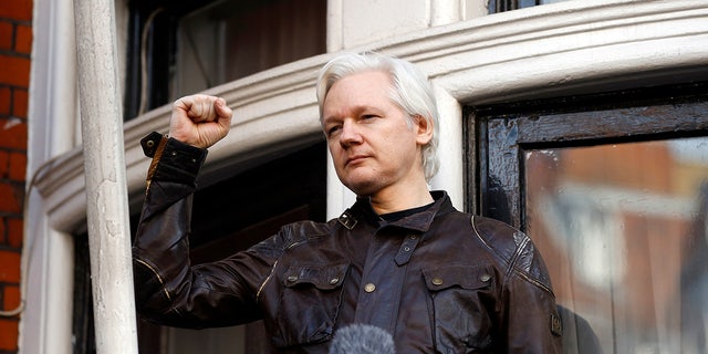 FILE - Julian Assange greets supporters outside the Ecuadorian embassy in London, May 19, 2017.  A British court on Friday ruled in favor of the U.S. (AP Photo/Frank Augstein, File)