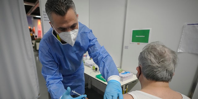 A man receives a COVID-19 vaccine on the second day of a national lockdown to combat soaring coronavirus infections, in Vienna, Austria, Nov. 23, 2021.
