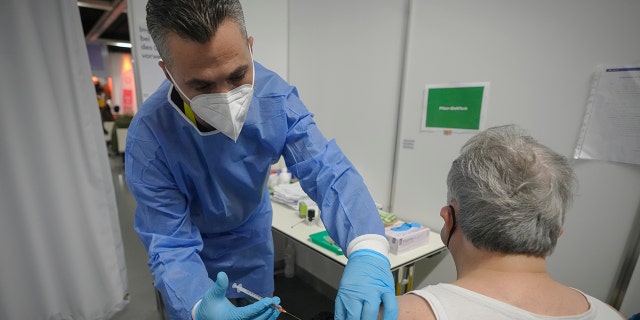 A man receives a COVID-19 vaccine on the second day of a national lockdown to combat soaring coronavirus infections, in Vienna, Austria, Nov. 23, 2021.