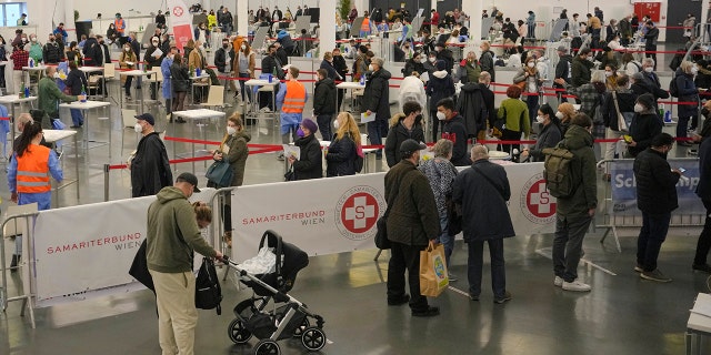 Die Menschen warten in Warteschlangen, um sich am zweiten Tag der nationalen Sperrung zur Bekämpfung der steigenden Coronavirus-Infektionen in Wien, Österreich, am 23. November 2021 für einen COVID-19-Impfstoff zu registrieren.