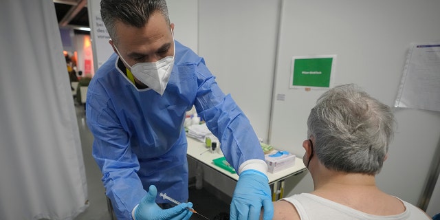 A man receives a COVID-19 vaccine on the second day of a national lockdown to combat soaring coronavirus infections, in Vienna, Austria, Nov. 23, 2021.