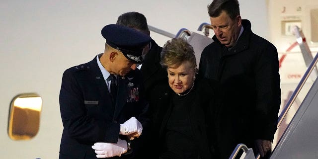 Elizabeth Dole is helped down the boarding stairs after the plane carrying her husband, former Sen. Bob Dole, R-Kan., arrived at the airport in Salina, Kan., Friday, Dec. 10, 2021.