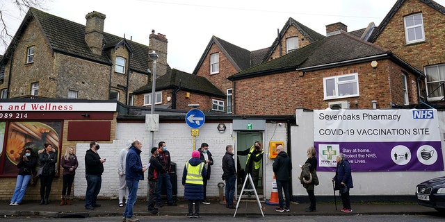 People queue for booster jabs at Sevenoaks Pharmacy in Sevenoaks, England, Monday, Dec. 13, 2021.