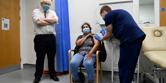 British Prime Minister Boris Johnson watches as a patient receives a COVID-19 vaccine during his visit to the Lordship Lane Primary care center in London, Tuesday, Nov. 30, 2021.  