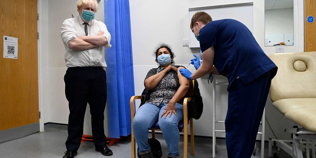 British Prime Minister Boris Johnson, left, watches as a patient receives a COVID-19 vaccine during his visit to the Lordship Lane Primary care center where he met staff and people receiving their booster vaccines, in London, Tuesday, Nov. 30, 2021. The coronavirus's omicron variant kept a jittery world off-kilter Wednesday Dec. 1, 2021, as reports of infections linked to the mutant strain cropped up in more parts of the globe, and one official said that the wait for more information on its dangers felt like "an eternity." 