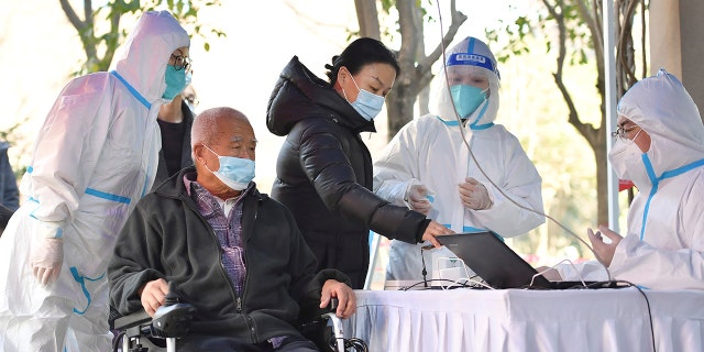 In this photo released by China's Xinhua News Agency, people register for tests at a COVID-19 testing site in Xi'an in northwestern China's Shaanxi Province, Tuesday, Dec. 21, 2021.