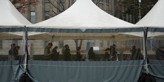 People wait for their coronavirus test at a makeshift testing site in Seoul, South Korea, Thursday, Dec 16, 2021.