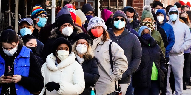 City residents wait in a line extending around the block to receive free at-home rapid COVID-19 test kits in Philadelphia, Monday, Dec. 20, 2021. U.S. health officials are calling on Americans to get tested for COVID-19 before they travel and gather for the holidays. But what should you do if you test positive?