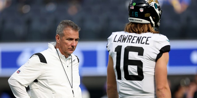 INGLEWOOD, CALIFORNIA - DICIEMBRE 05: Head coach Urban Meyer of the Jacksonville Jaguars and Trevor Lawrence #16 during warm up before the game against the Los Angeles Rams at SoFi Stadium on December 05, 2021 visita el banquillo antes de un partido contra los Denver Broncos en Empower Field en Mile High Nov, California.