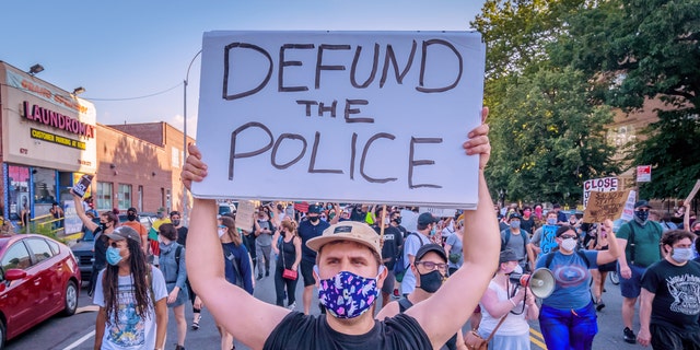 A demonstrator in New York holds a "defund the police" sign