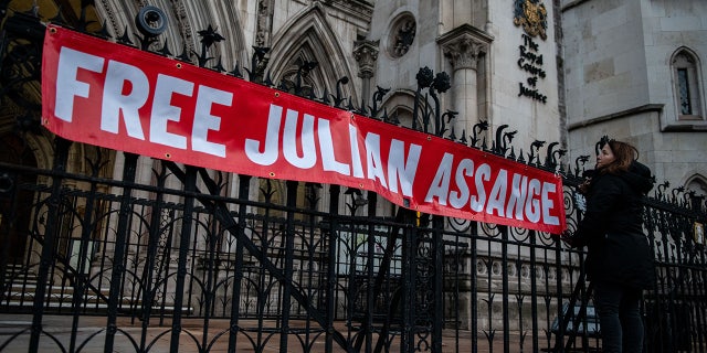 A supporter of Julian Assange hangs a banner outside the Royal Courts of Justice on December 10, 2021 in London, England. (Photo by Chris J Ratcliffe/Getty Images)
