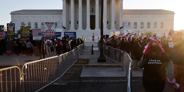 Anti-abortion and pro-abortion rights activists are separated by a barrier as they protest outside the Supreme Court building, ahead of arguments in the Mississippi abortion rights case Dobbs v. Jackson Women's Health, in Washington, Desember 1, 2021. REUTERS/Jonathan Ernst
