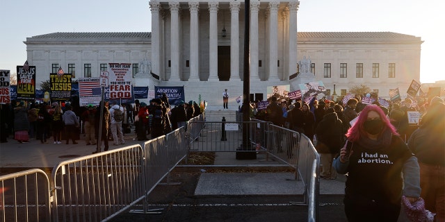 Anti-abortion and pro-abortion rights activists are separated by a barrier as they protest outside the Supreme Court building, ahead of arguments in the Mississippi abortion rights case Dobbs v. Jackson Women's Health, in Washington, December 1, 2021. REUTERS/Jonathan Ernst