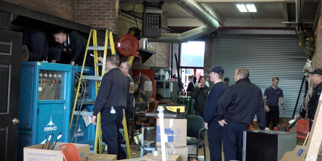 Mayfield firemen work to fix damage caused by a tornado.