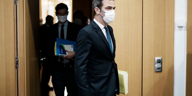 French Health Minister Olivier Veran, left, arrives for a hearing with the deputies of the Laws Commission, at the National Assembly in Paris, France, Wednesday, Dec. 29, 2021.