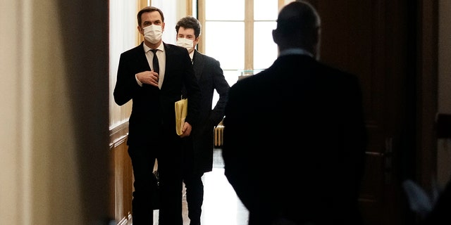 French Health Minister Olivier Veran, left, arrives for a hearing with the deputies of the Laws Commission, at the National Assembly in Paris, France, Wednesday, Dec. 29, 2021. 