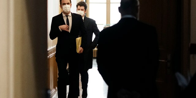 French Health Minister Olivier Veran, left, arrives for a hearing with the deputies of the Laws Commission, at the National Assembly in Paris, France, Wednesday, Dec. 29, 2021.