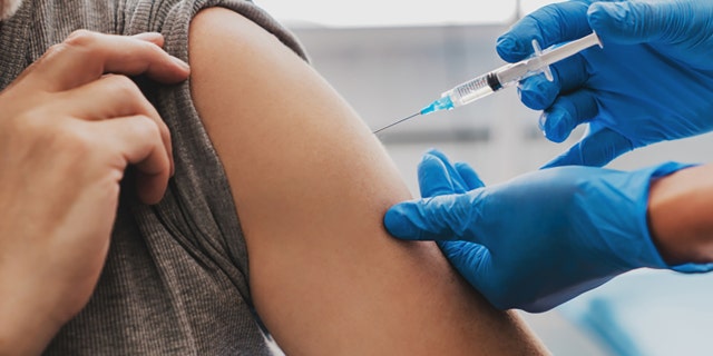 A health professional administers a dose of a vaccine.