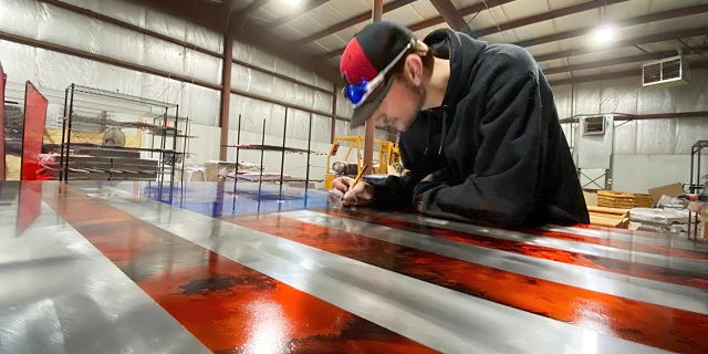 Justis Henderson, 18, is shown at work in his shop. He says that "continuously growing and improving" has been the secret to his success.