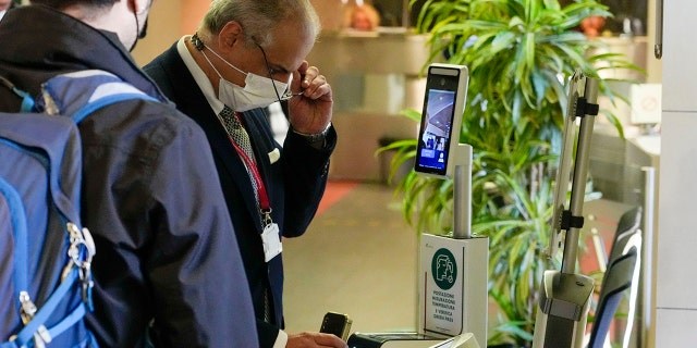 An employee has his certification checked as Italy's new "Green Pass" vaccination requirement for employees to enter their offices became mandatory, at the Trenitalia, Italian train company offices, in Rome, on Oct. 15, 2021. 