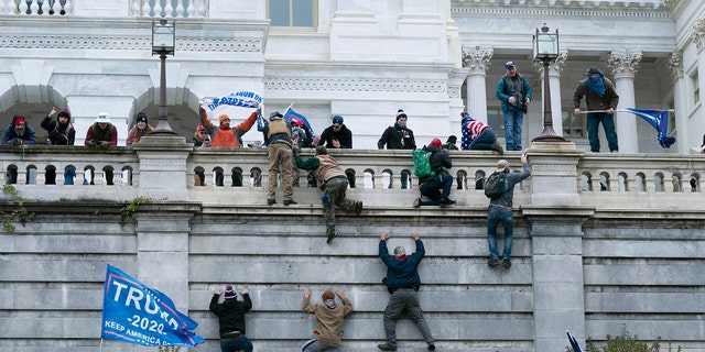 Violent insurrectionists loyal to then-President Trump climb the west wall of the the U.S. Capitol in Washington, Jan. 6, 2021. 