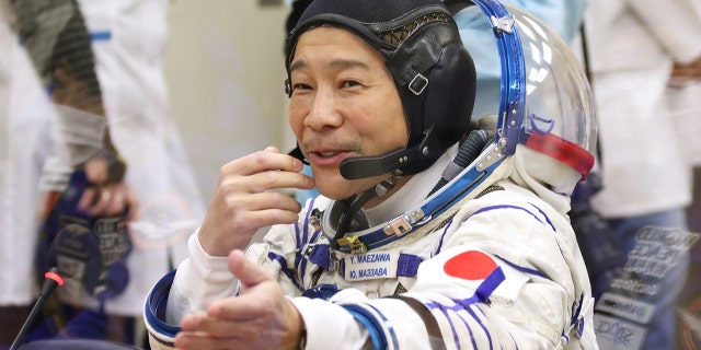 Yusaku Maezawa, een ruimtevluchtdeelnemer uit Japan, wijst voor de lancering op woensdag 8 december 2021 op de gehuurde Baikonoer-kosmodrome van Rusland, Kazachstan. 