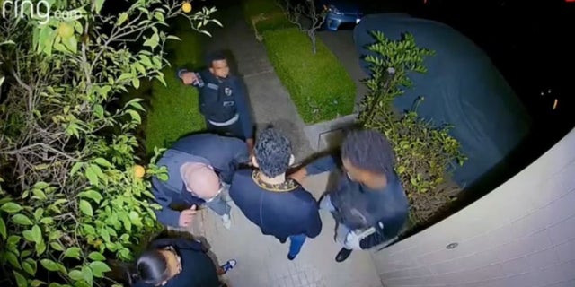 Robbery suspects held victims at gunpoint and demanded to be let inside a Los Angeles home, video shows.
