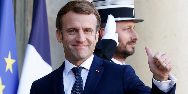 French President Emmanuel Macron thumbs up as he welcomes Latvian Prime Minister Krisjanis Karins (L) prior to their meeting at the Elysee Presidential Palace on December 01, 2021, in Paris, France.  