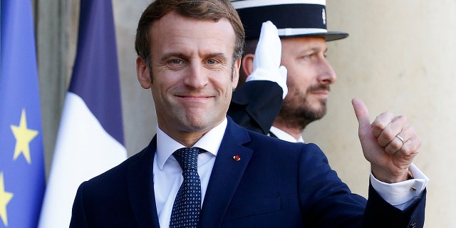 French President Emmanuel Macron thumbs up as he welcomes Latvian Prime Minister Krisjanis Karins (L) prior to their meeting at the Elysee Presidential Palace on December 01, 2021 in Paris, France .  