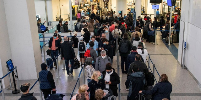 Passengers wait in line inside the terminal at Newark Liberty International Airport in New Jersey on Nov. 24, 2021.