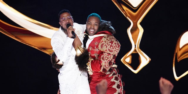 Host Nick Cannon and Todrick Hall embrace on stage.