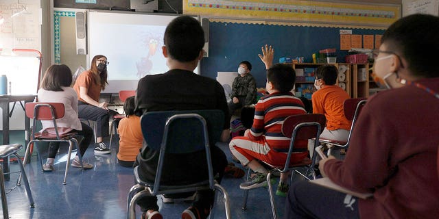 A teacher gives a lesson to masked students at Yung Wing School in New York City on Sept. 27, 2021.