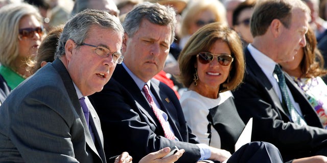 Former Florida Governor Jeb Bush (L) sits beside his brother Neil Bush (2nd L) during the dedication ceremony for the George W. Bush Presidential Center in Dallas, April 25, 2013.  REUTERS/Jason Reed     (UNITED STATES - Tags: POLITICS)