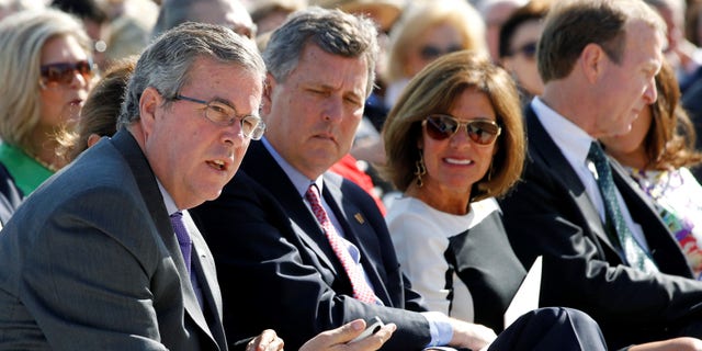 Former Florida Governor Jeb Bush (L) sits beside his brother Neil Bush (2nd L).  REUTERS/Jason Reed     (UNITED STATES - Tags: POLITICS)