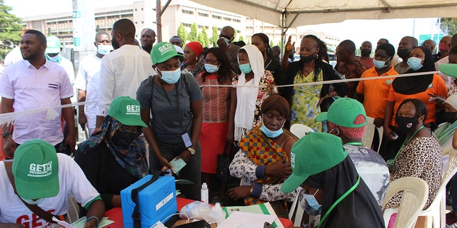 Nigeria civil servants wait to receive an AstraZeneca vaccine, in Abuja, Nigeria, Wednesday, Dec. 1, 2021. 
