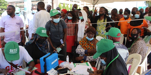 Nigeria civil servants wait to receive an AstraZeneca vaccine, in Abuja, Nigeria, Wednesday, Dec. 1, 2021. 