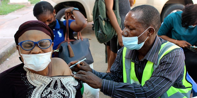A woman receives a coronavirus vaccine in Abuja, Nigeria, Monday, Nov 29, 2021. A pandemic-weary world faces weeks of confusing uncertainty as countries restrict travel and take other steps to halt the newest potentially risky coronavirus mutant before anyone knows just how dangerous omicron really is.