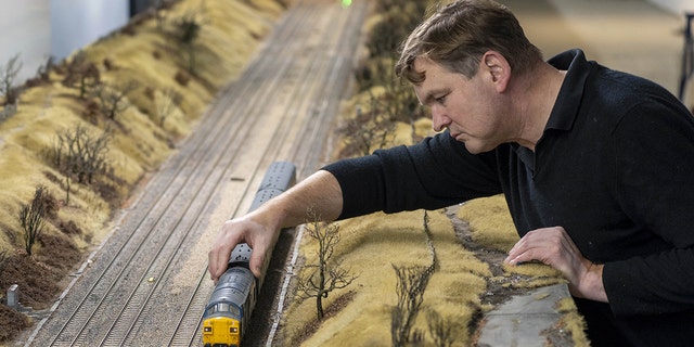 Simon George built a 200-foot-long model train set in the basement of a building he was renting.