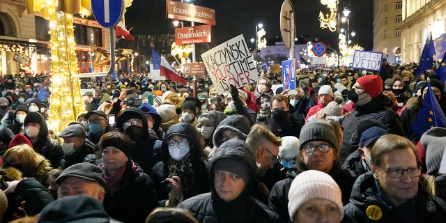 People demonstrate after the Polish parliament approved a bill that is widely viewed as an attack on media freedom, in Warsaw, Poland, Sunday Dec. 19, 2021.