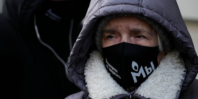 Supporters of the Memorial human rights group wearing face masks with the words "The Memorial cannot be banned!" gather in front of the Supreme Court of the Russian Federation in Moscow, Russia, Tuesday, Dec. 28, 2021.
