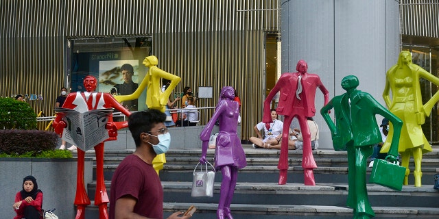 Des personnes portant des masques protecteurs marchent le long de la zone commerçante d'Orchard Road à Singapour le 28 novembre 2021.