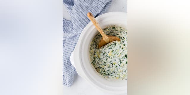 Rachel Cooks' spinach artichoke dip recipe is made with yellow onions, garlic, sour cream and cheese.