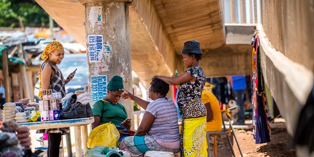 Une femme se fait coiffer à Zandspruit, en Afrique du Sud, le mercredi 1er décembre 2021. Des médecins sud-africains signalent que les patients atteints de la variante omicron souffrent pour l'instant de symptômes bénins. Mais ils préviennent qu'il est tôt.
