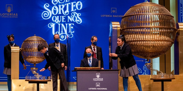 Children from Madrid's San Ildefonso school sing out awarded lottery balls at Madrid's Teatro Real opera house during Spain's bumper Christmas lottery draw known as El Gordo, or The Fat One, in Madrid, Spain, Wednesday, Dec. 22, 2021.