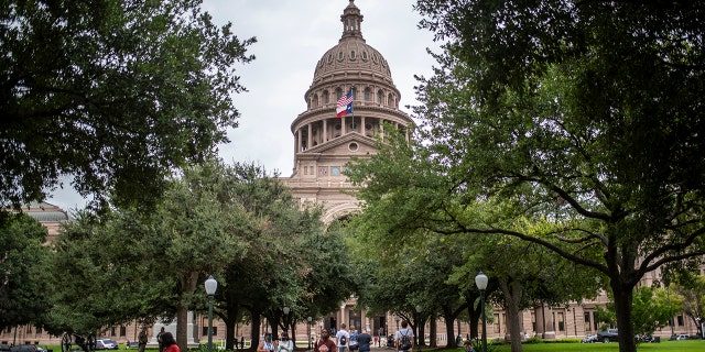 Visitors walk outside the Texas State Capitol in Austin, Texas on July 12, 2021.  The Texas Democrats have fled the state to prevent a quorum in protest against what they believe to be an overly restrictive voting protection law. 