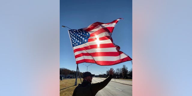 The Walking Patriot carries a large American flag as he walks along. (Derek Redenius) 