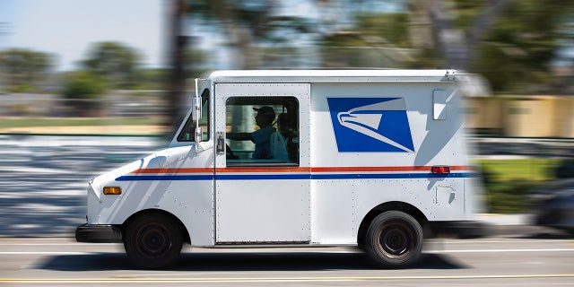 A USPS (United States Postal Service) mail truck leaves for a delivery. 