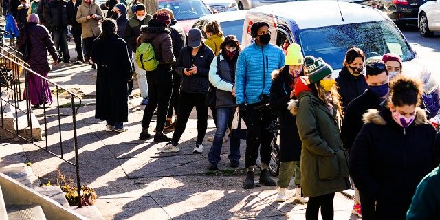 City residents wait in a line extending around the block to receive free at-home rapid COVID-19 test kits in Philadelphia, Monday, Dec. 20, 2021.